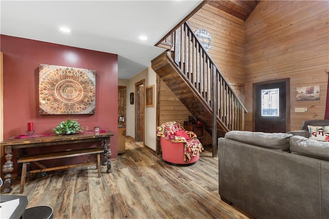 living room featuring hardwood / wood-style floors, wood walls, and vaulted ceiling