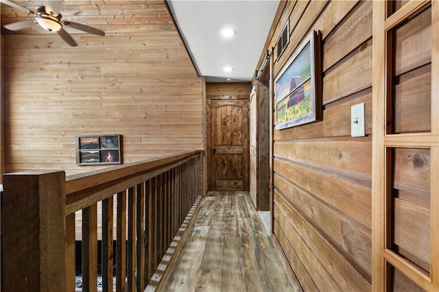 corridor featuring wood walls and wood-type flooring