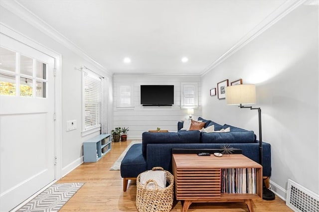 living room featuring crown molding and light hardwood / wood-style flooring