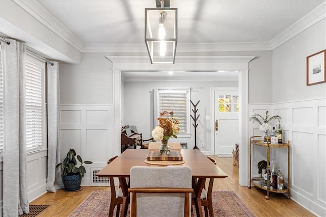 dining room featuring light hardwood / wood-style flooring and crown molding