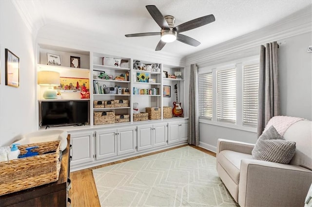 living area with ceiling fan, light hardwood / wood-style floors, and ornamental molding