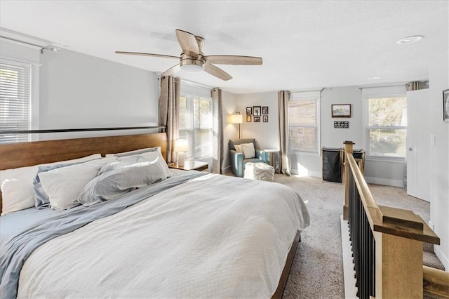 carpeted bedroom featuring multiple windows and ceiling fan