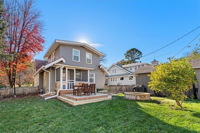 back of property with a sunroom, a yard, and a deck