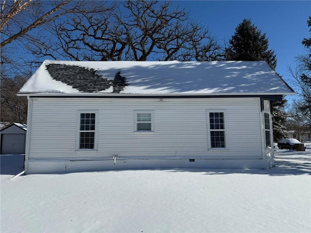 view of snow covered rear of property