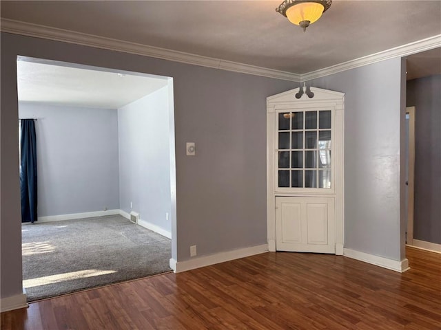 empty room with dark hardwood / wood-style floors and ornamental molding