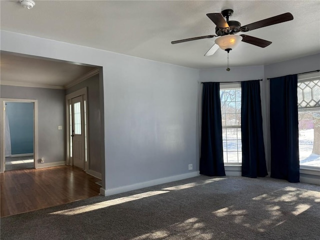 carpeted empty room with ceiling fan and crown molding