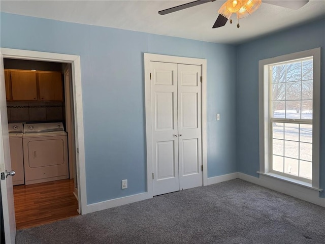 unfurnished bedroom featuring a closet, dark carpet, ceiling fan, and washing machine and clothes dryer