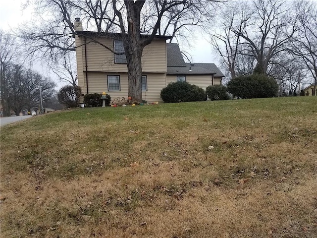 view of side of home with a yard