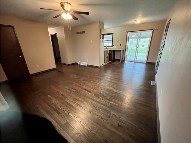 unfurnished living room featuring ceiling fan and dark hardwood / wood-style flooring