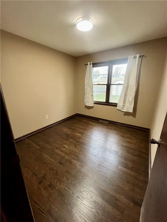 empty room featuring dark wood-type flooring