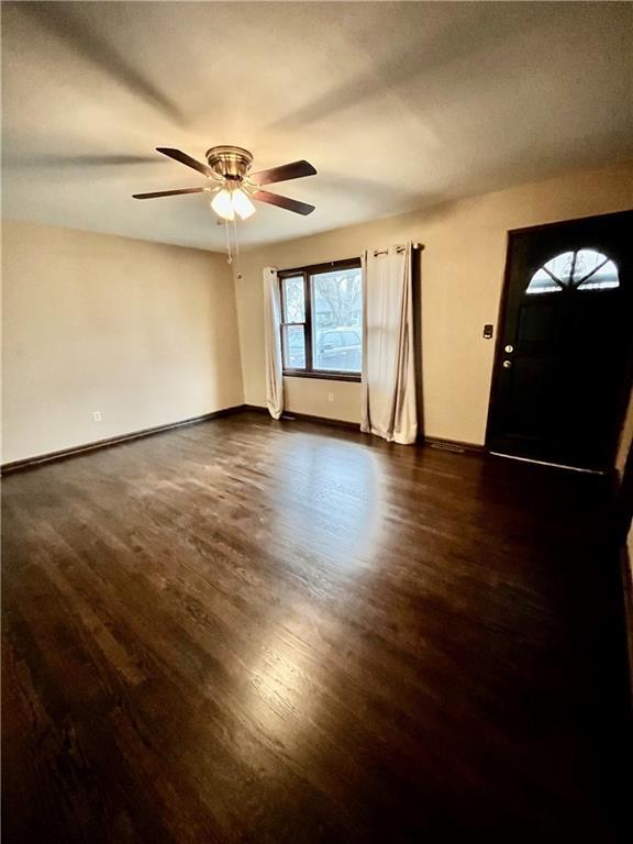 interior space with ceiling fan and dark hardwood / wood-style flooring