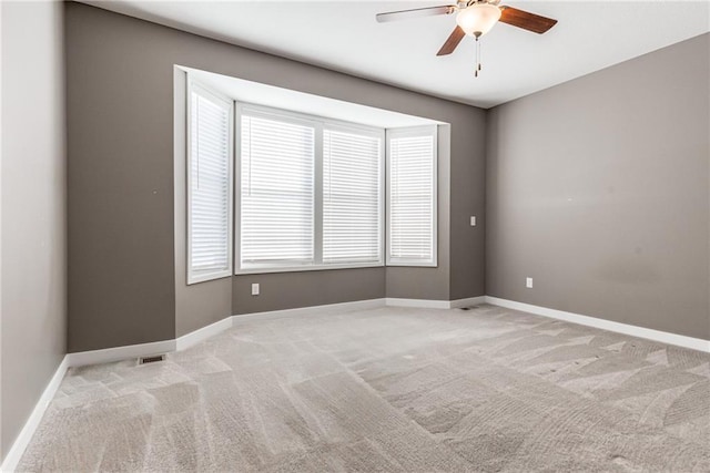 empty room with light carpet, a wealth of natural light, and baseboards