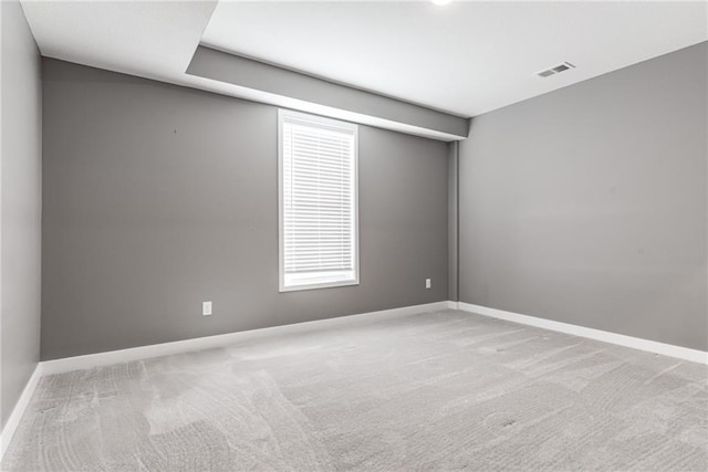 carpeted empty room featuring baseboards and visible vents