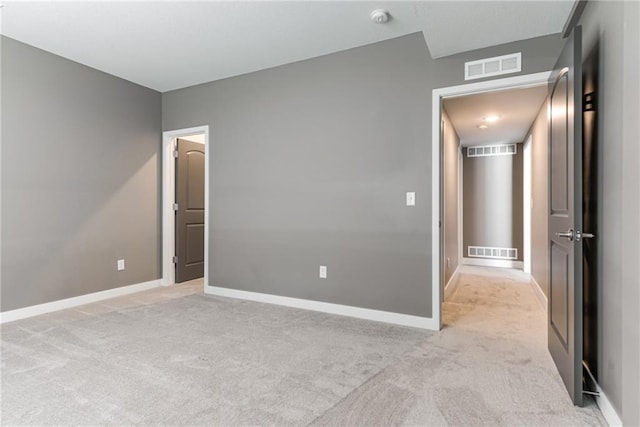 unfurnished bedroom featuring visible vents and light carpet