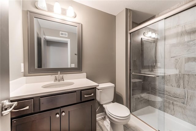 full bath with vanity, a shower stall, toilet, and visible vents