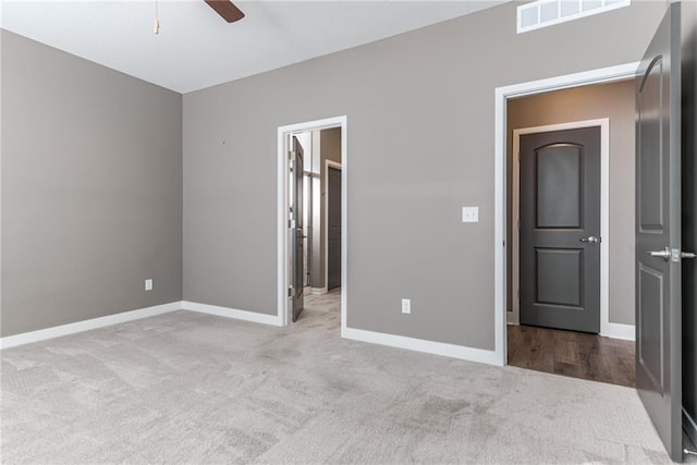 unfurnished bedroom with ceiling fan, carpet, visible vents, and baseboards