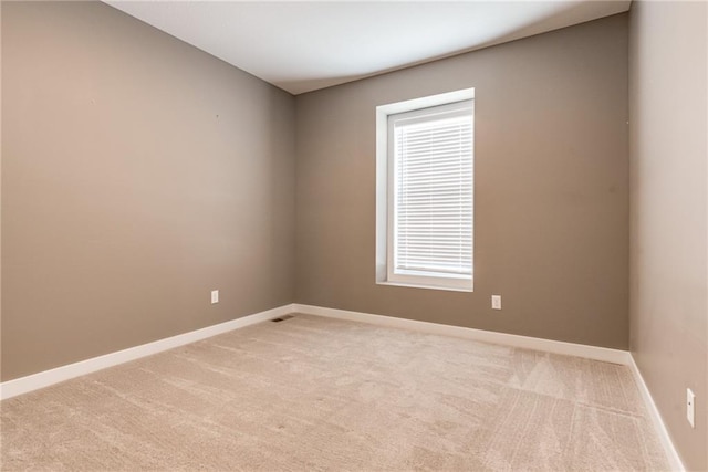 spare room with a wealth of natural light, baseboards, and carpet