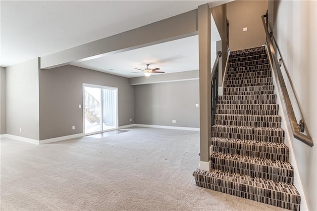 staircase with baseboards, a ceiling fan, and carpet flooring