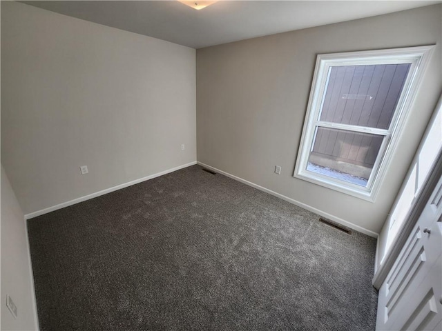 empty room with dark colored carpet