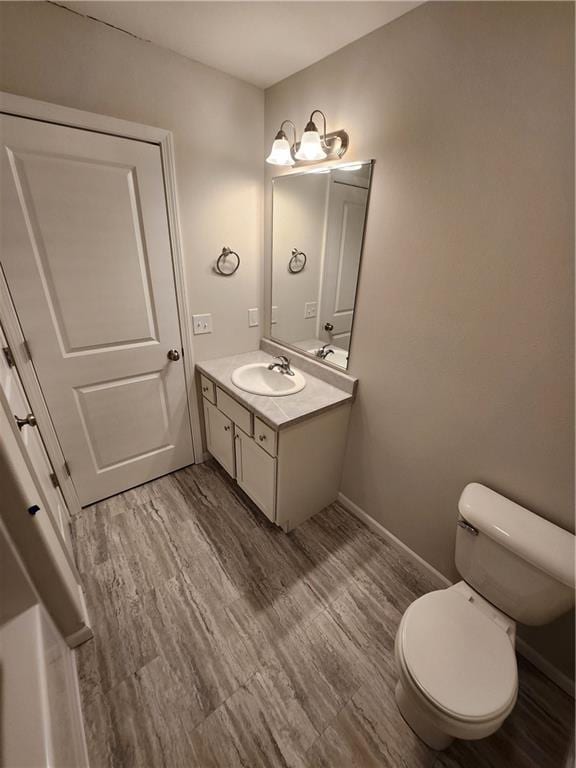 bathroom with hardwood / wood-style flooring, vanity, and toilet