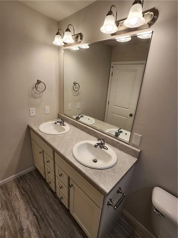 bathroom with hardwood / wood-style floors, vanity, and toilet