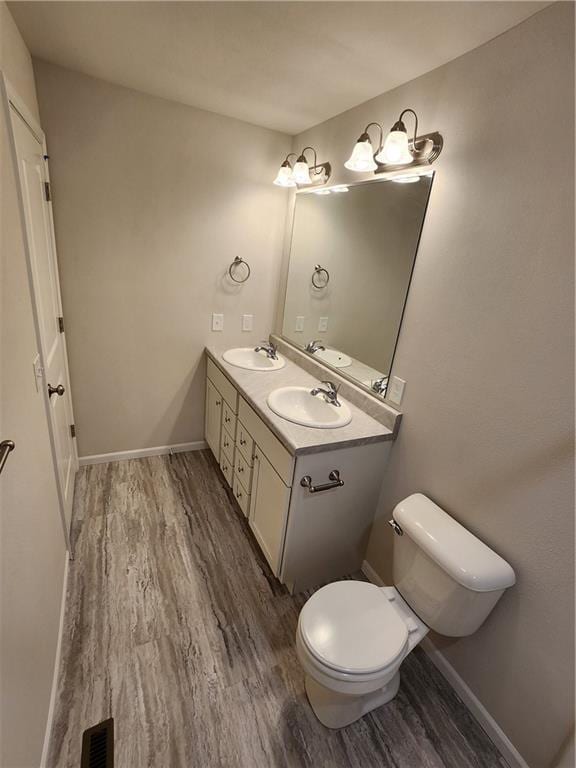 bathroom with vanity, hardwood / wood-style flooring, and toilet