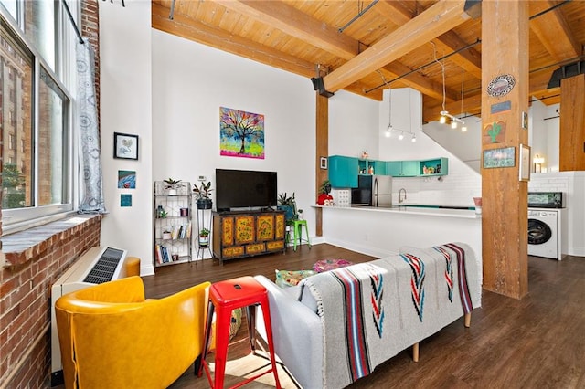 living room with washer / dryer, wood ceiling, beam ceiling, and wood finished floors