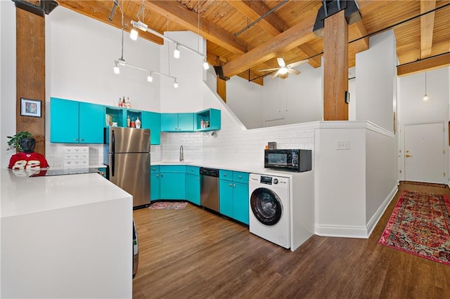 kitchen with blue cabinets, stainless steel appliances, a high ceiling, dark wood-type flooring, and washer / dryer