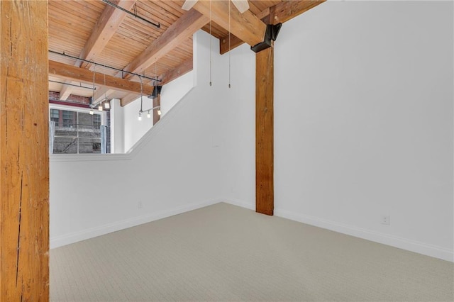 unfurnished room with carpet floors, baseboards, and beam ceiling