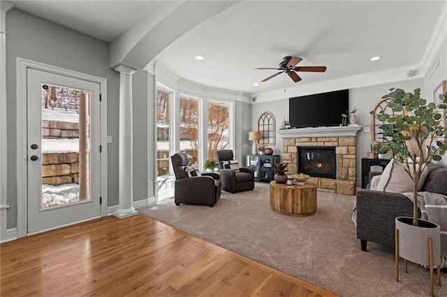 living room with ceiling fan, wood-type flooring, plenty of natural light, and a fireplace