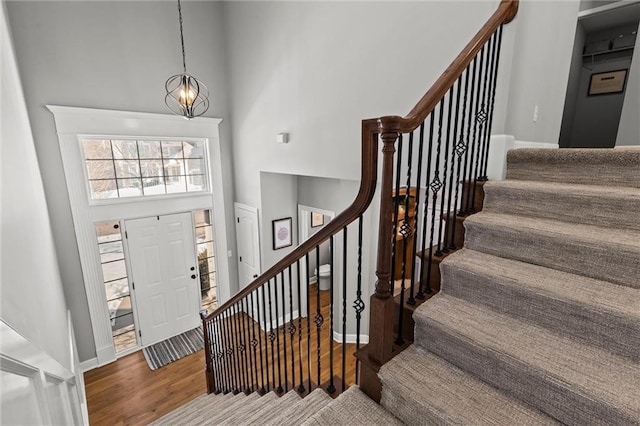 foyer entrance with a notable chandelier, a high ceiling, and hardwood / wood-style flooring