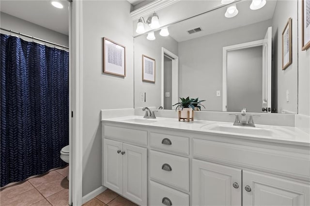 bathroom with toilet, tile patterned floors, and vanity