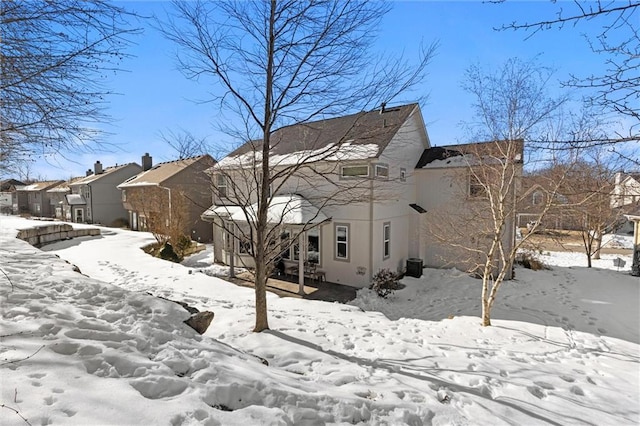 snow covered rear of property with central air condition unit