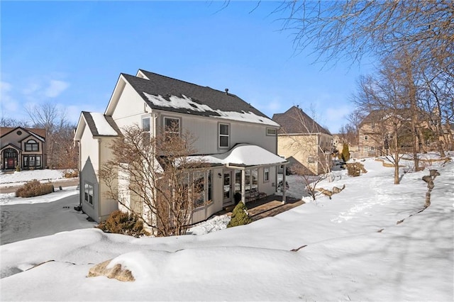 view of snow covered rear of property