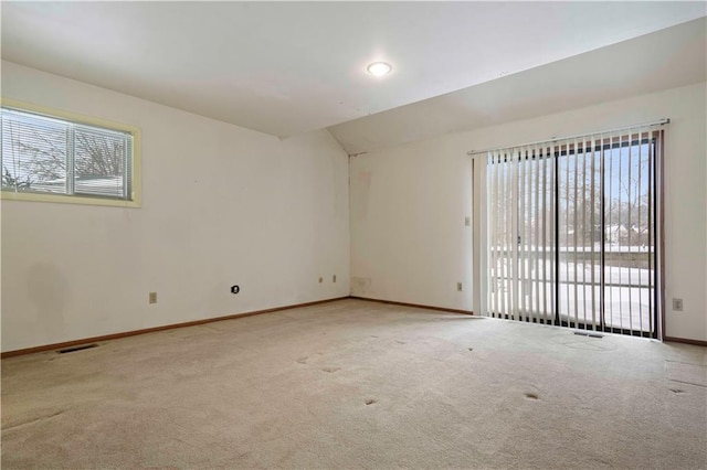 spare room with plenty of natural light and light colored carpet