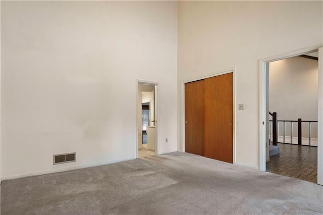 carpeted empty room with a towering ceiling