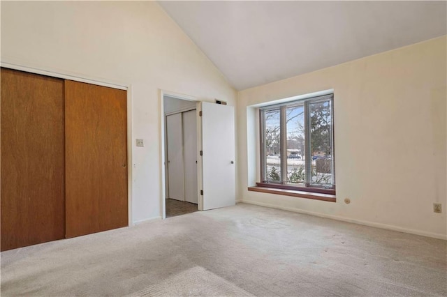 unfurnished bedroom featuring carpet floors and high vaulted ceiling