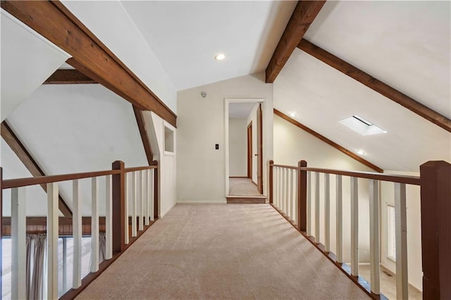 hallway featuring light carpet and vaulted ceiling with skylight