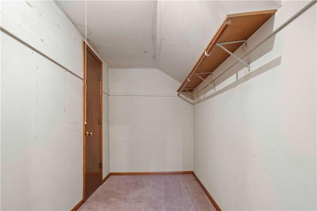 walk in closet featuring light carpet and lofted ceiling