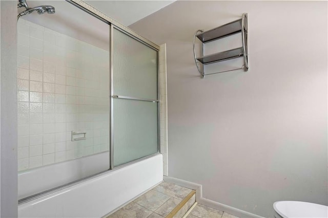 bathroom with combined bath / shower with glass door, tile patterned floors, and toilet