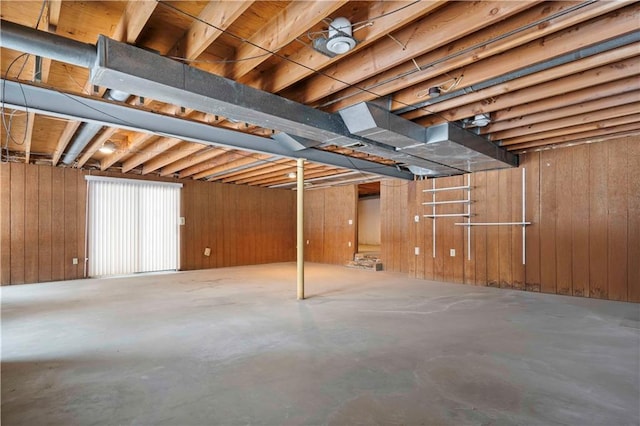 basement featuring wood walls