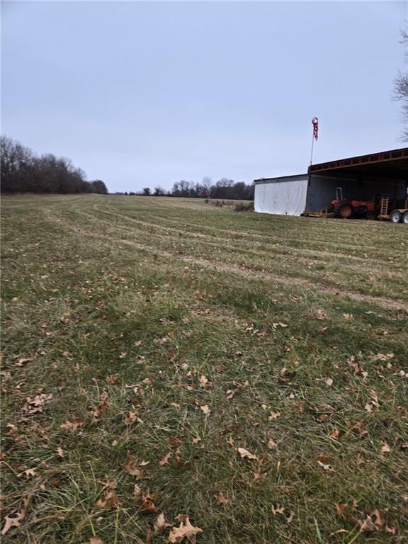 view of yard with a rural view and an outdoor structure