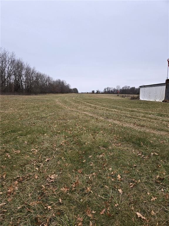 view of yard with a rural view and an outdoor structure