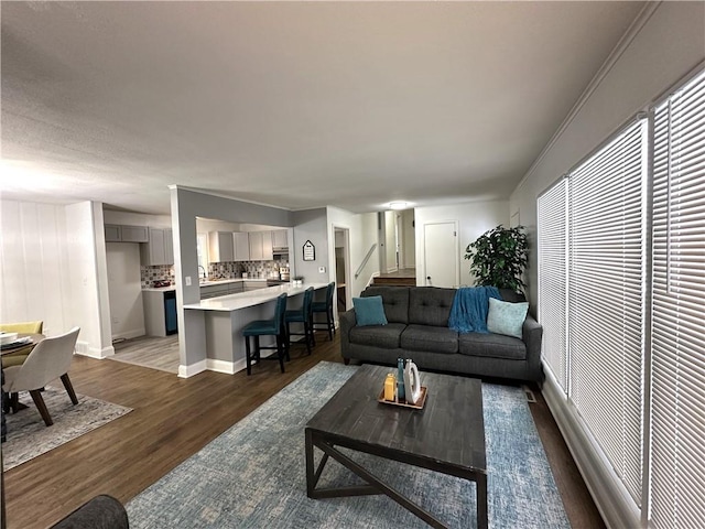 living room with dark hardwood / wood-style flooring and crown molding