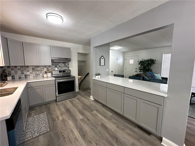 kitchen featuring tasteful backsplash, dishwasher, gray cabinets, stainless steel range with electric cooktop, and a textured ceiling