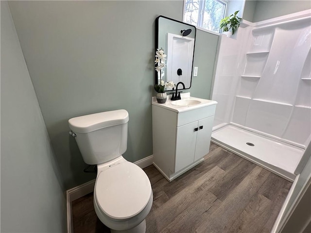 bathroom featuring a shower, wood-type flooring, toilet, and vanity