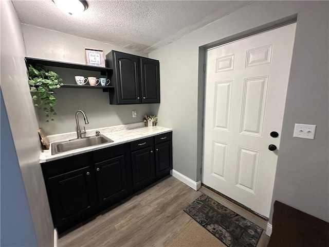 kitchen featuring light hardwood / wood-style floors, sink, and a textured ceiling