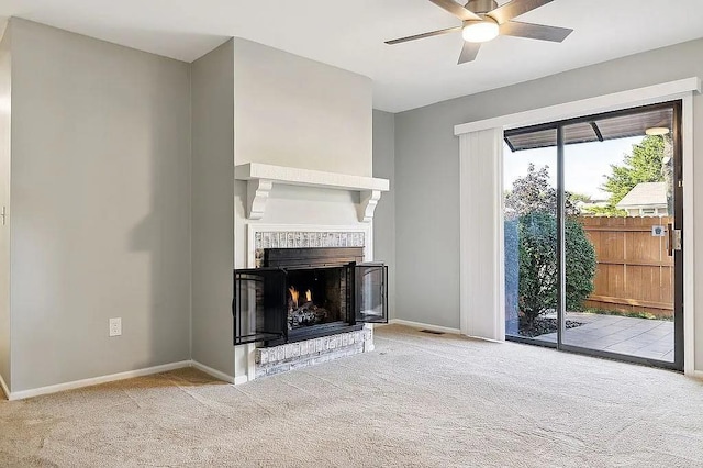 unfurnished living room featuring ceiling fan, a fireplace, and light carpet