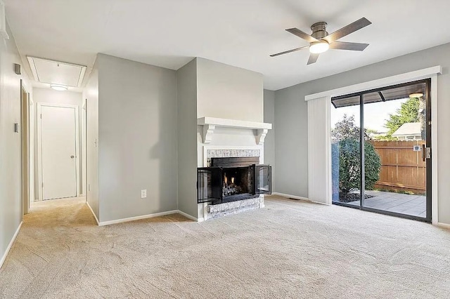 unfurnished living room featuring ceiling fan, light colored carpet, and a brick fireplace