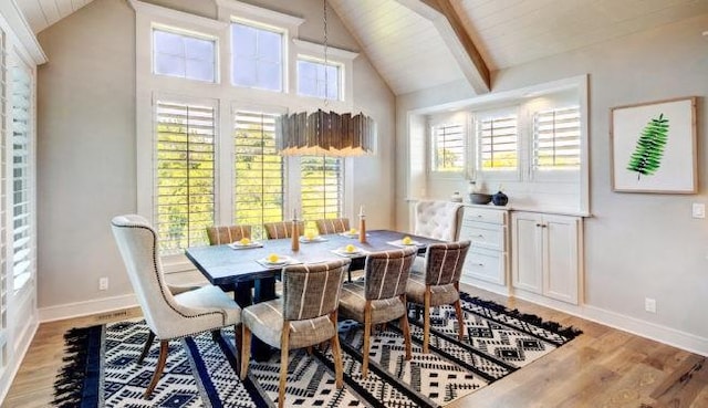 dining space featuring vaulted ceiling with beams and light wood-type flooring